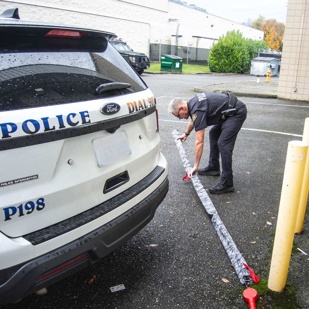 Officer lays stop stick on parking lot ground