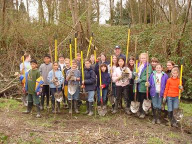Students from Marysville School District holding shovels, wearing rain boots.